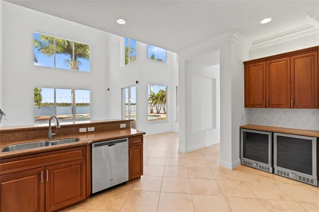 a view of an empty room with kitchen and a window