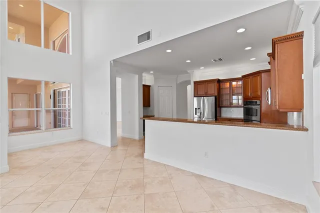 an empty room with floor to ceiling windows and a ceiling fan
