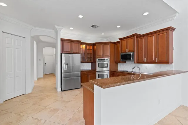 a kitchen with stainless steel appliances granite countertop a refrigerator and a stove top oven
