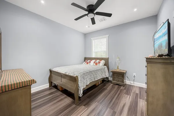 a bedroom with a bed and wooden floor