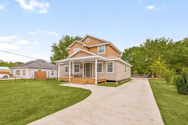 a front view of a house with a garden and trees