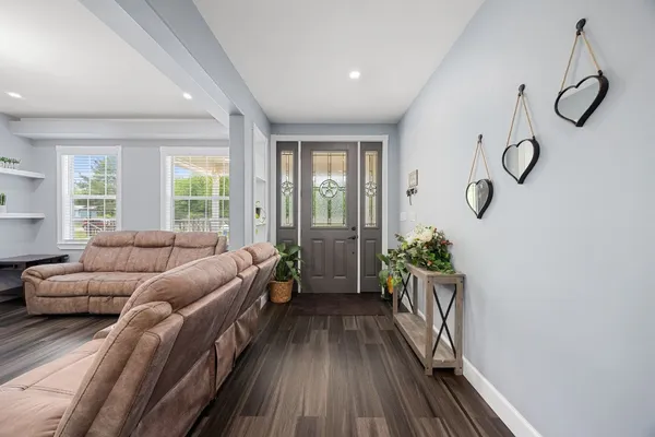 a living room with furniture a fireplace and a large window