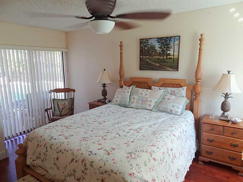 22338 Ensenada Way Boca Raton, FL 33433 - Photo 12 of 20 a bedroom with a bed and wooden floor