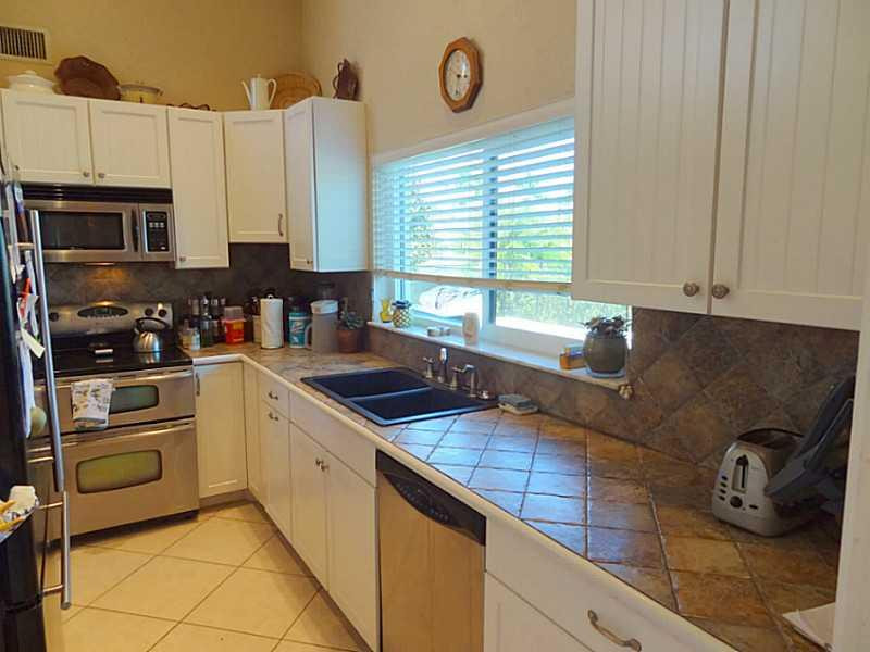 22338 Ensenada Way Boca Raton, FL 33433 - Photo 8 of 20 a kitchen with granite countertop a sink a stove and cabinets