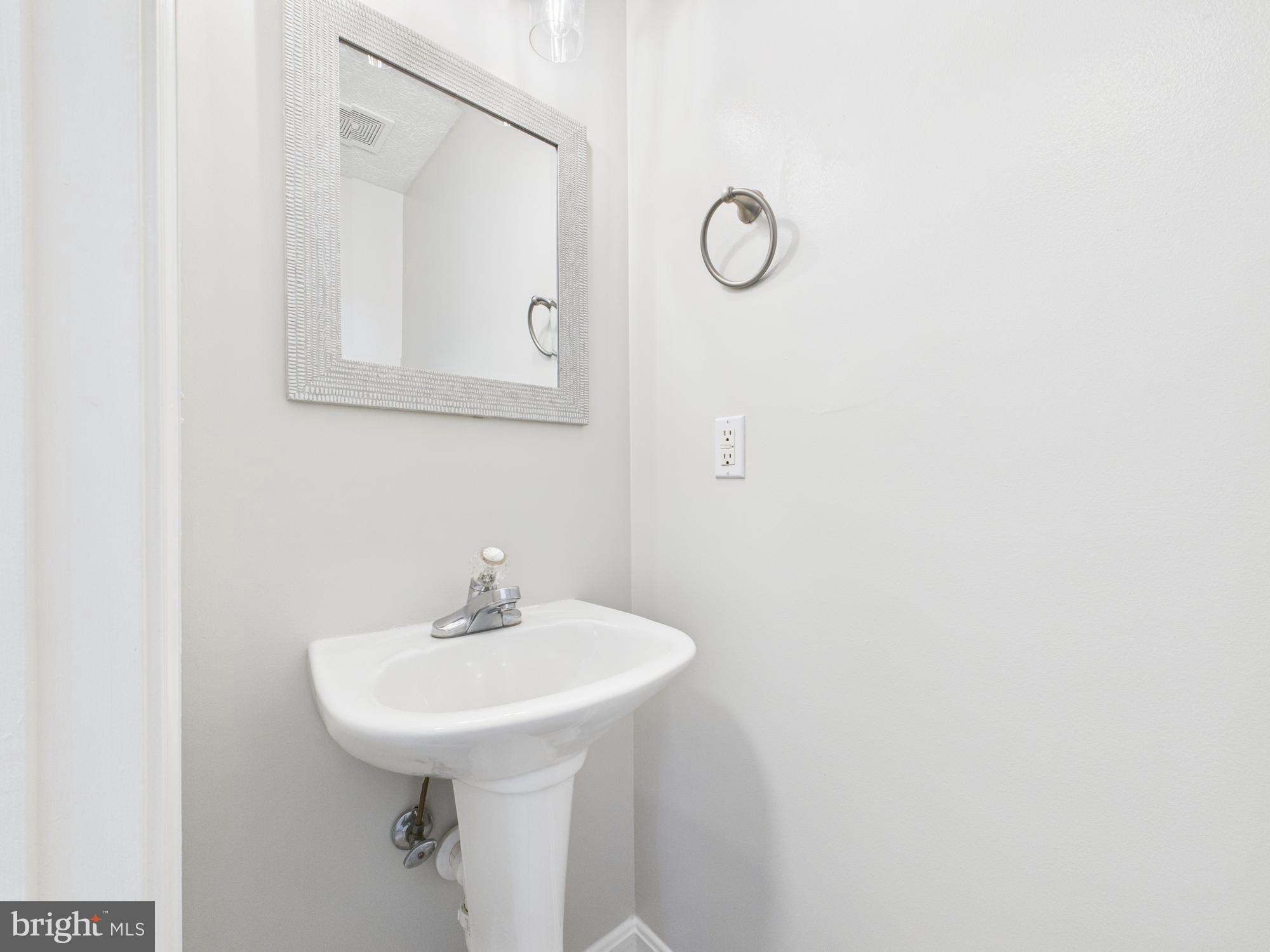 8067 Brookstone Court, Unit 100 Severn, MD 21144 - Photo 12 of 36 a bathroom with a sink a mirror and a shower