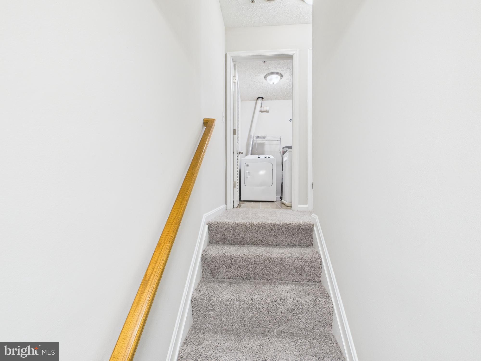 8067 Brookstone Court, Unit 100 Severn, MD 21144 - Photo 13 of 36 a view of a hallway with wooden floor and staircase