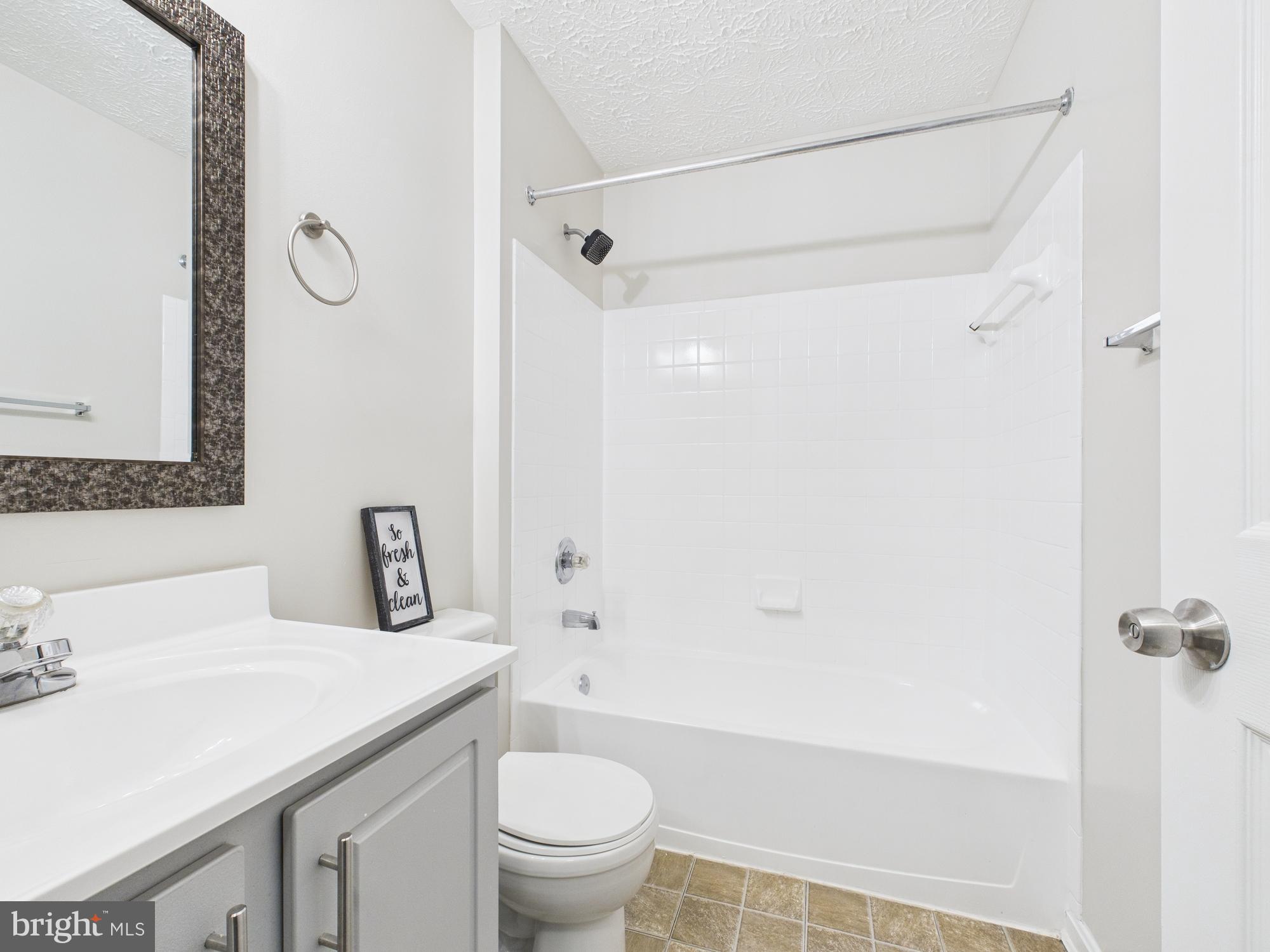 8067 Brookstone Court, Unit 100 Severn, MD 21144 - Photo 20 of 36 a bathroom with a granite countertop sink a toilet and shower