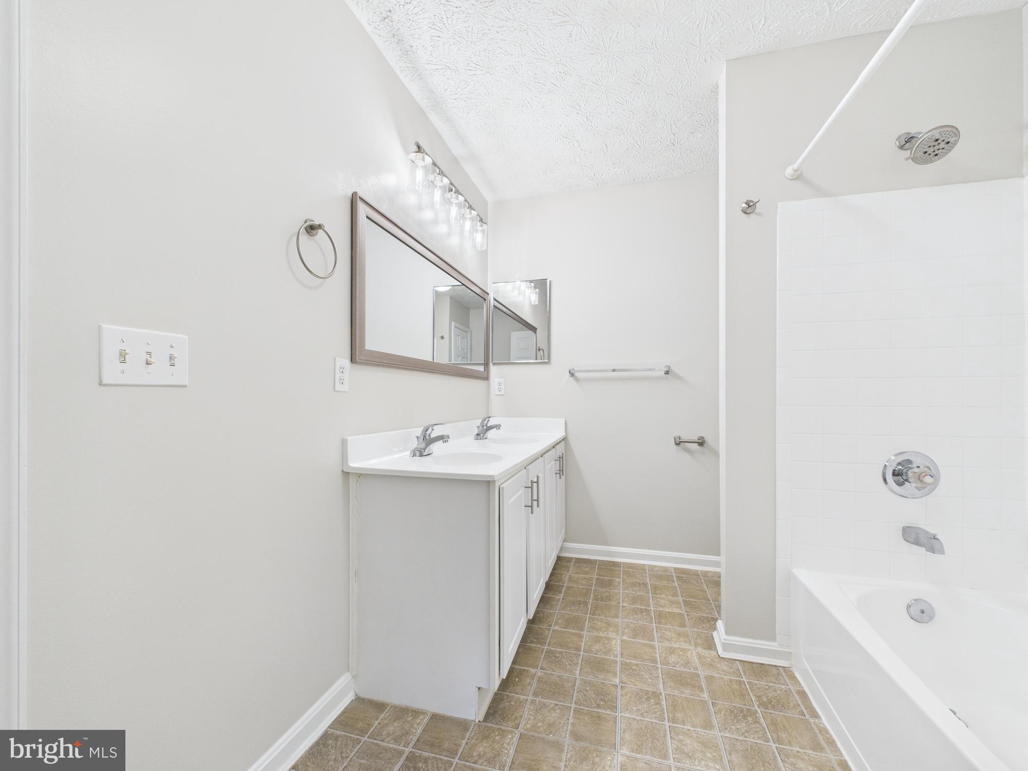 8067 Brookstone Court, Unit 100 Severn, MD 21144 - Photo 27 of 36 a bathroom with a sink a toilet and shower