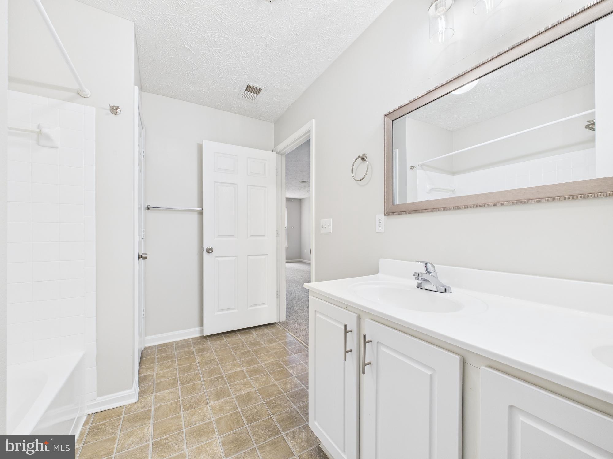 8067 Brookstone Court, Unit 100 Severn, MD 21144 - Photo 28 of 36 a bathroom with a sink and a mirror