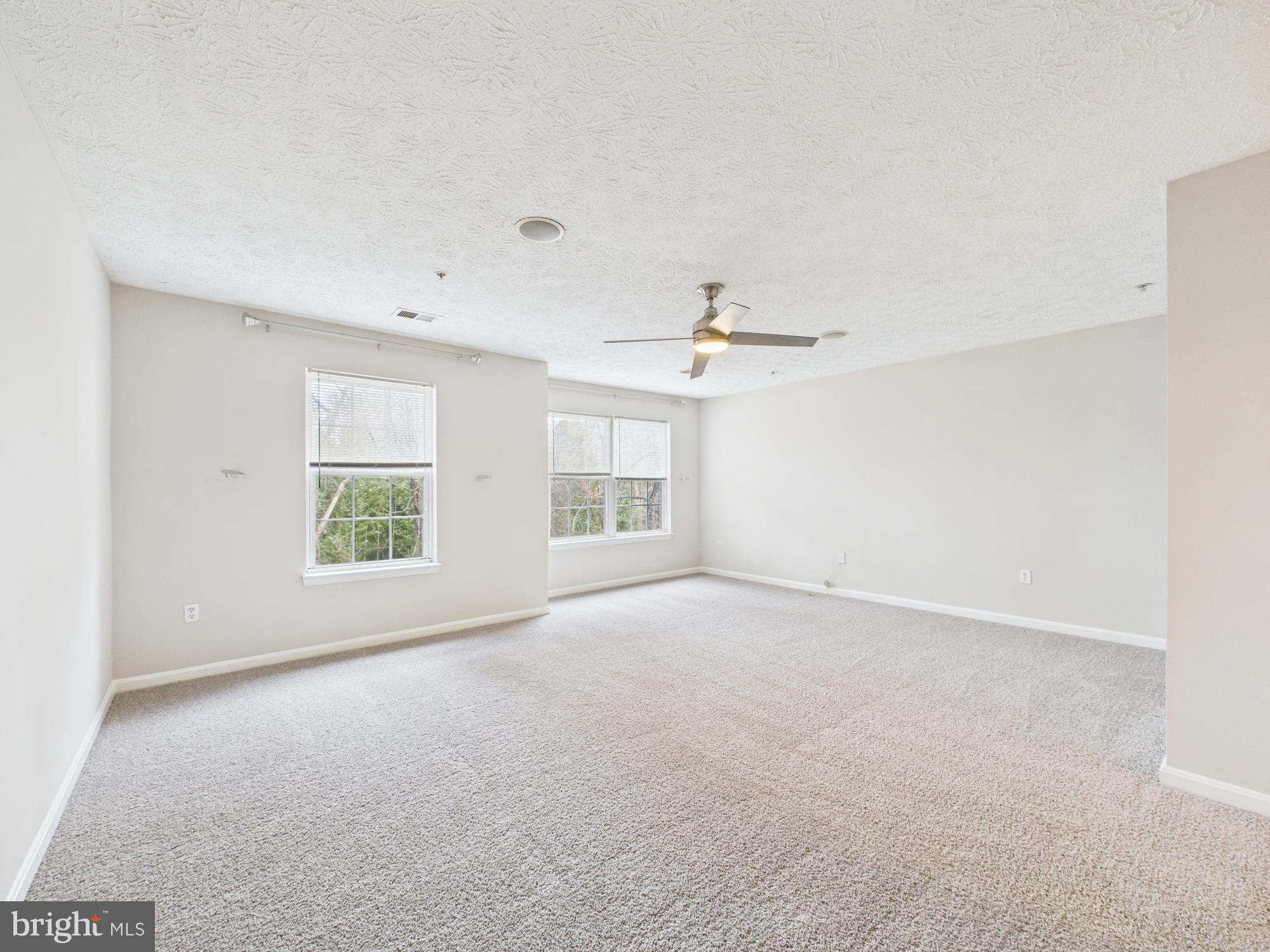 8067 Brookstone Court, Unit 100 Severn, MD 21144 - Photo 30 of 36 an empty room with windows and ceiling fan