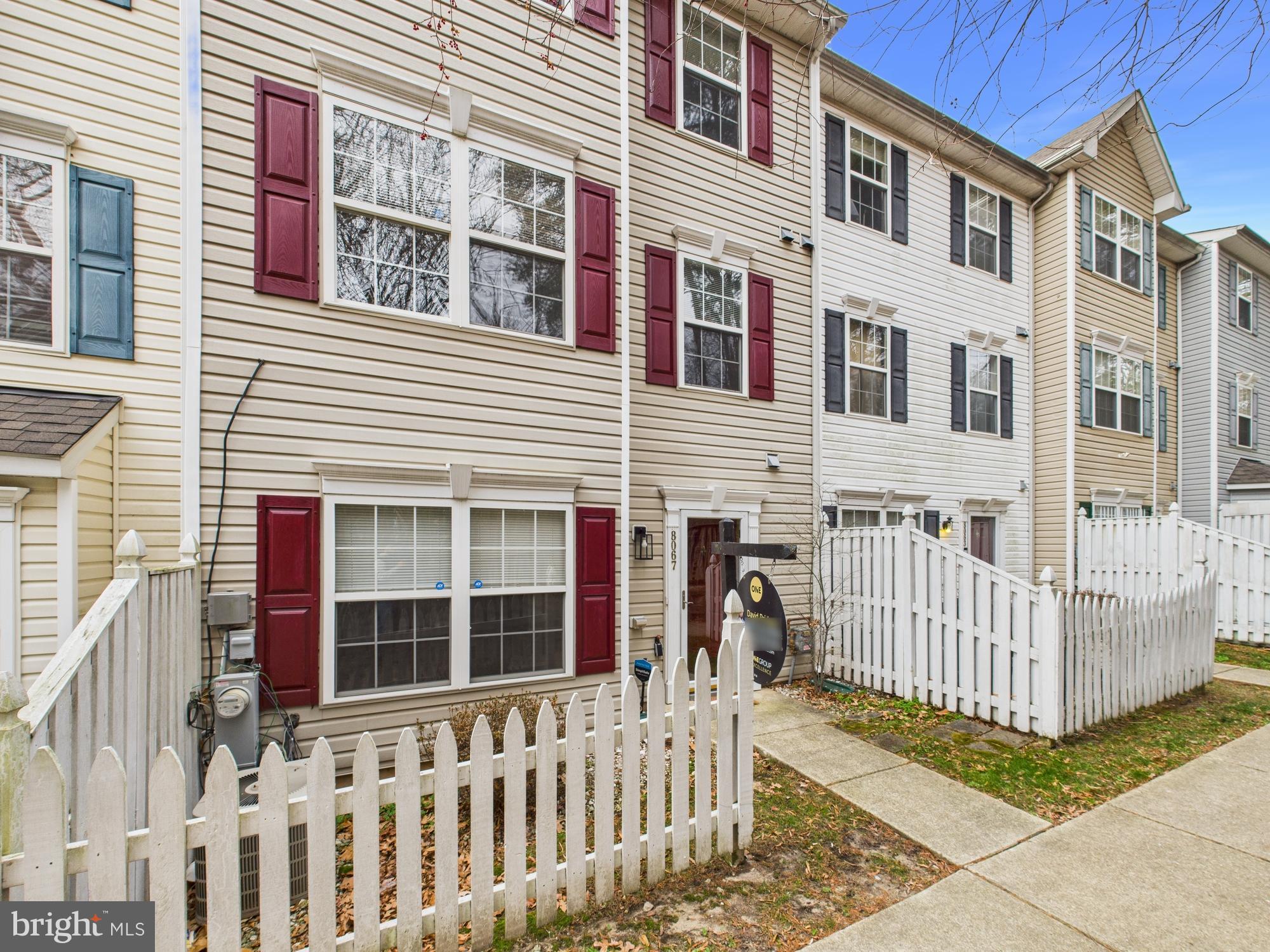 8067 Brookstone Court, Unit 100 Severn, MD 21144 - Photo 35 of 36 a front view of a house with a small yard