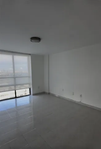 a front view of multi story residential apartment building with yard and parking space