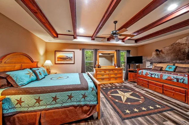 a bedroom with a bed and a lamp on dresser