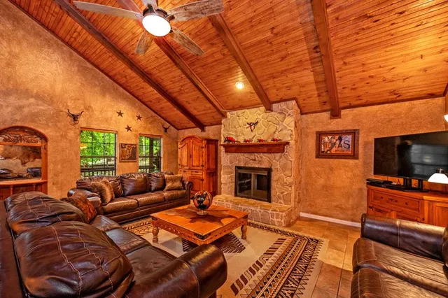 a view of a patio with couches under an umbrella next to a yard