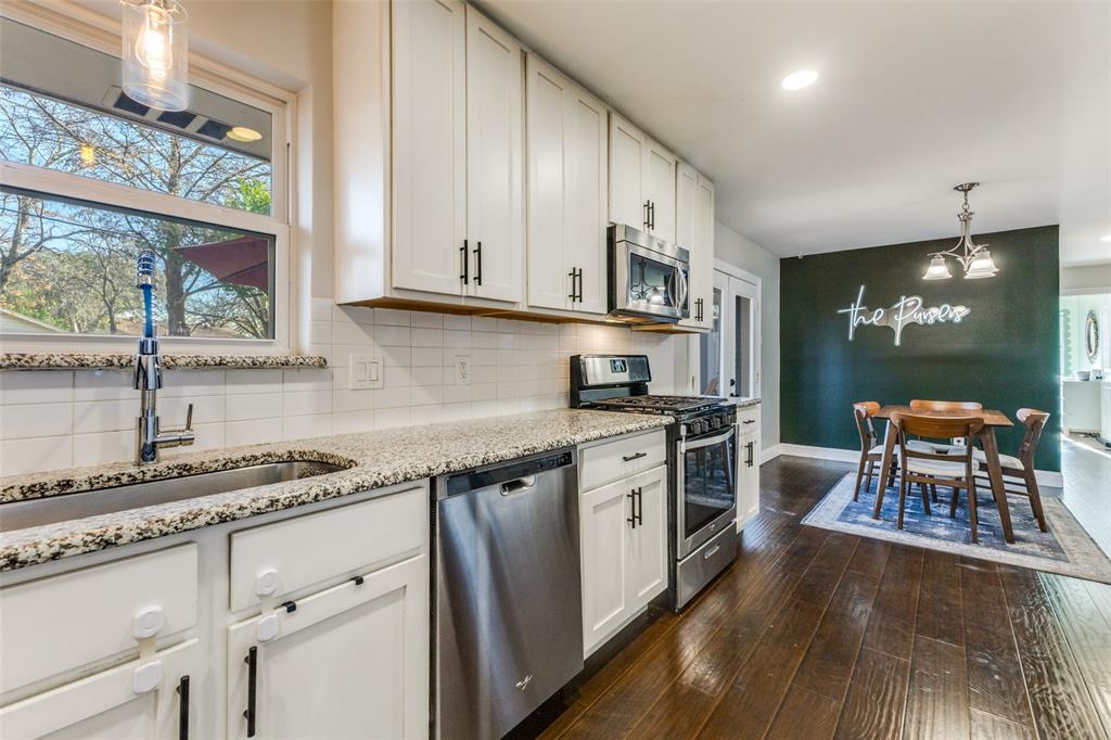 a kitchen with stainless steel appliances granite countertop a stove a sink and a refrigerator