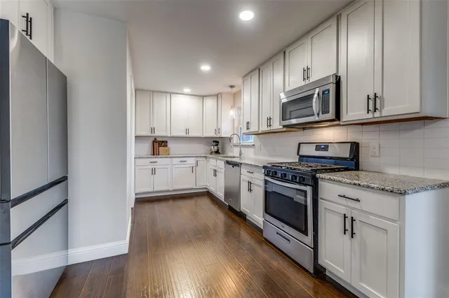 a kitchen with stainless steel appliances granite countertop a stove a sink and a microwave