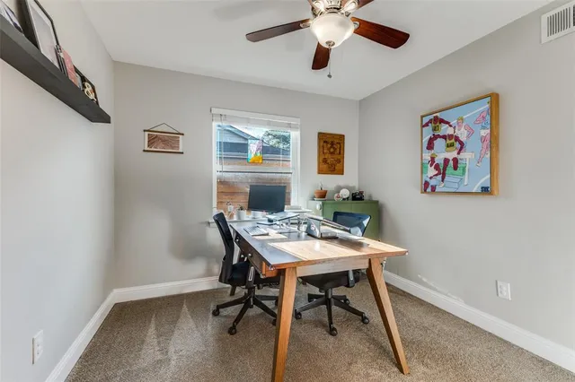 a view of a workspace with furniture and a window