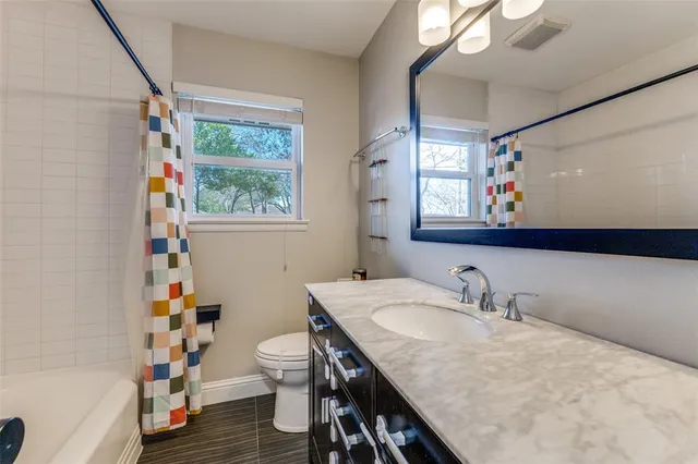 a bathroom with a sink a toilet and a window