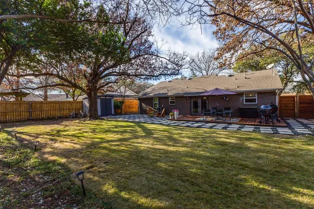 a table and chairs under an umbrella in front of house