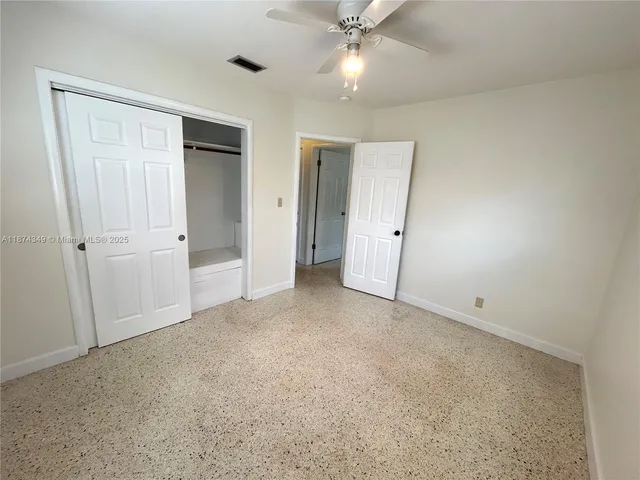 an empty room with a ceiling fan and a window