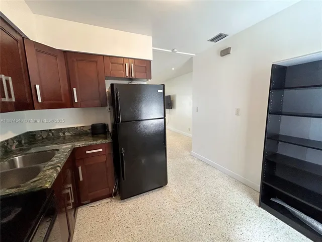 a kitchen with a refrigerator stove and cabinets