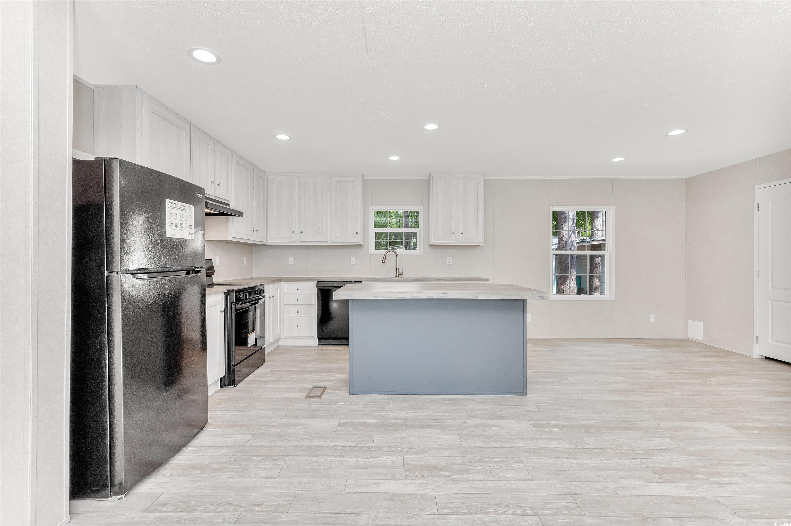 398 West Canal Street Murrells Inlet, SC 29576 - Photo 8 of 40 Kitchen with black appliances, white cabinets, and