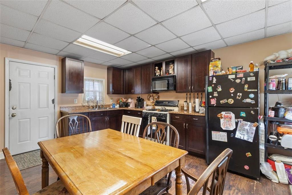 403 Ormsby Avenue Pittsburgh, PA 15210 - Photo 25 of 32 a kitchen with stainless steel appliances granite countertop a table chairs sink and cabinets