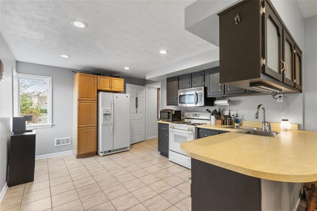 403 Ormsby Avenue Pittsburgh, PA 15210 - Photo 7 of 32 a kitchen with refrigerator and cabinets
