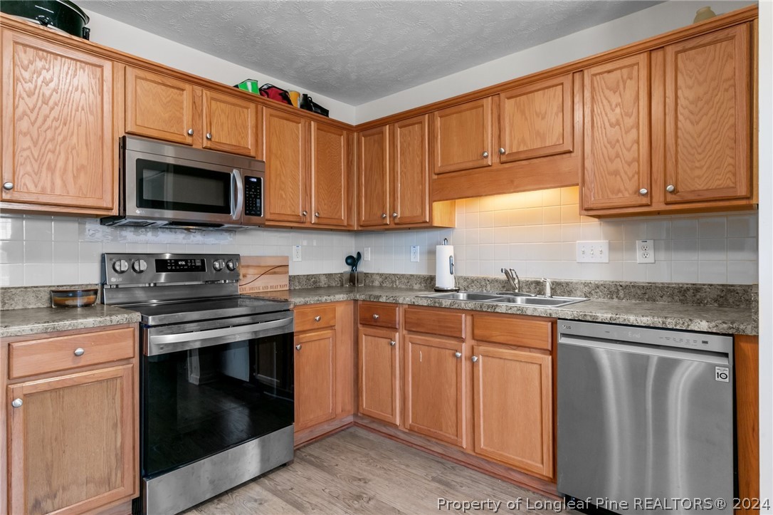 1949 Yellowbrick Road Fayetteville, NC 28314 - Photo 13 of 34 a kitchen with stainless steel appliances granite countertop a stove sink microwave and cabinets