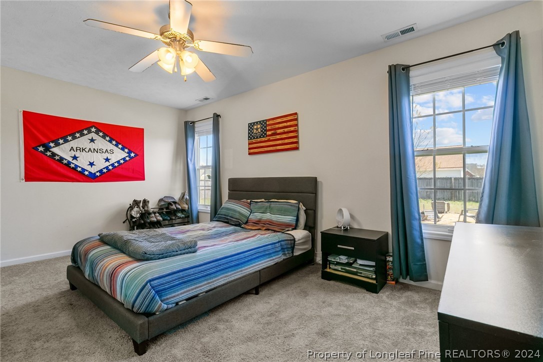 1949 Yellowbrick Road Fayetteville, NC 28314 - Photo 23 of 34 a bedroom with a bed and a chandelier