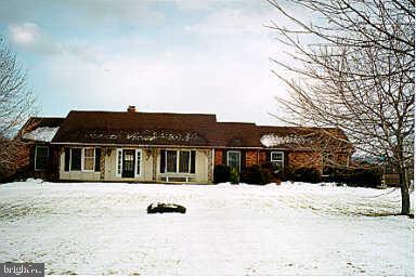 a view of house with a snow in the yard