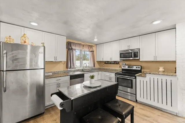 a kitchen with stainless steel appliances a refrigerator stove microwave and sink