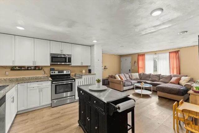 a kitchen with kitchen island granite countertop a sink counter top space appliances and cabinets