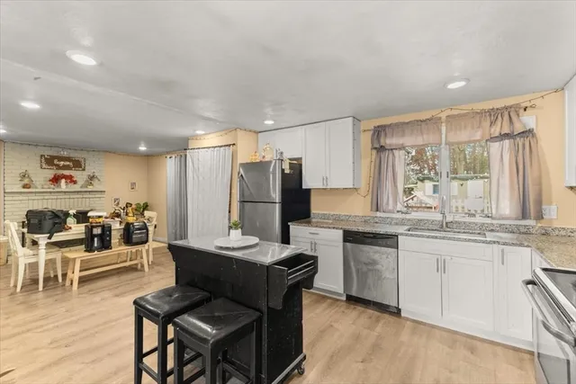 a kitchen with stainless steel appliances kitchen island granite countertop a sink and cabinets
