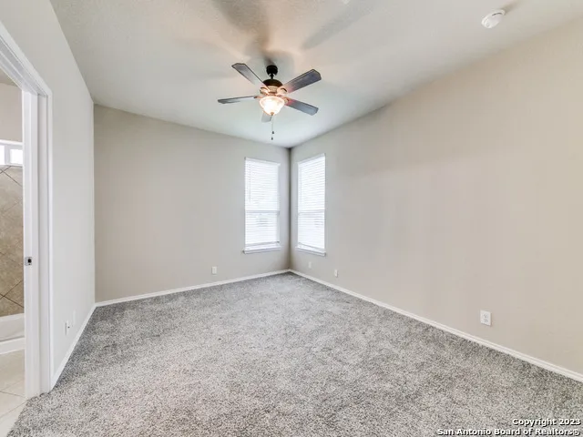 an empty room with closet and ceiling fan