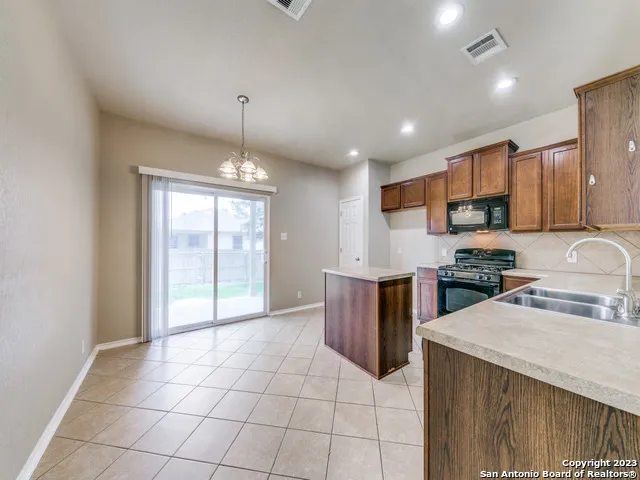 a kitchen with stainless steel appliances granite countertop a stove top oven a sink a counter top space and cabinets