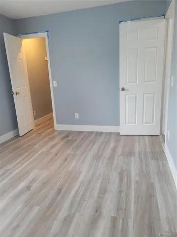 an empty room with wooden floor and closet