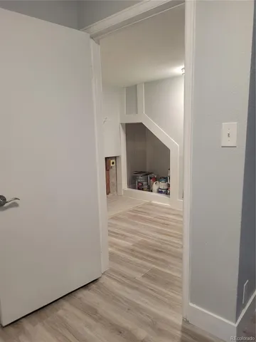 a view of a hallway with wooden floor and a cabinet