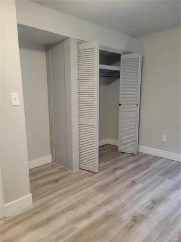 an empty room with wooden floor and closet