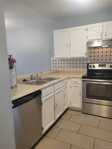a kitchen with a sink stove and cabinets