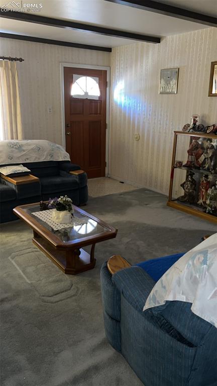 1041 Florence Avenue Colorado Springs, CO 80905 - Photo 10 of 27 Carpeted living area featuring beam ceiling and wallpapered walls