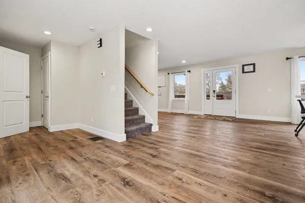 a dining room with furniture a chandelier and wooden floor