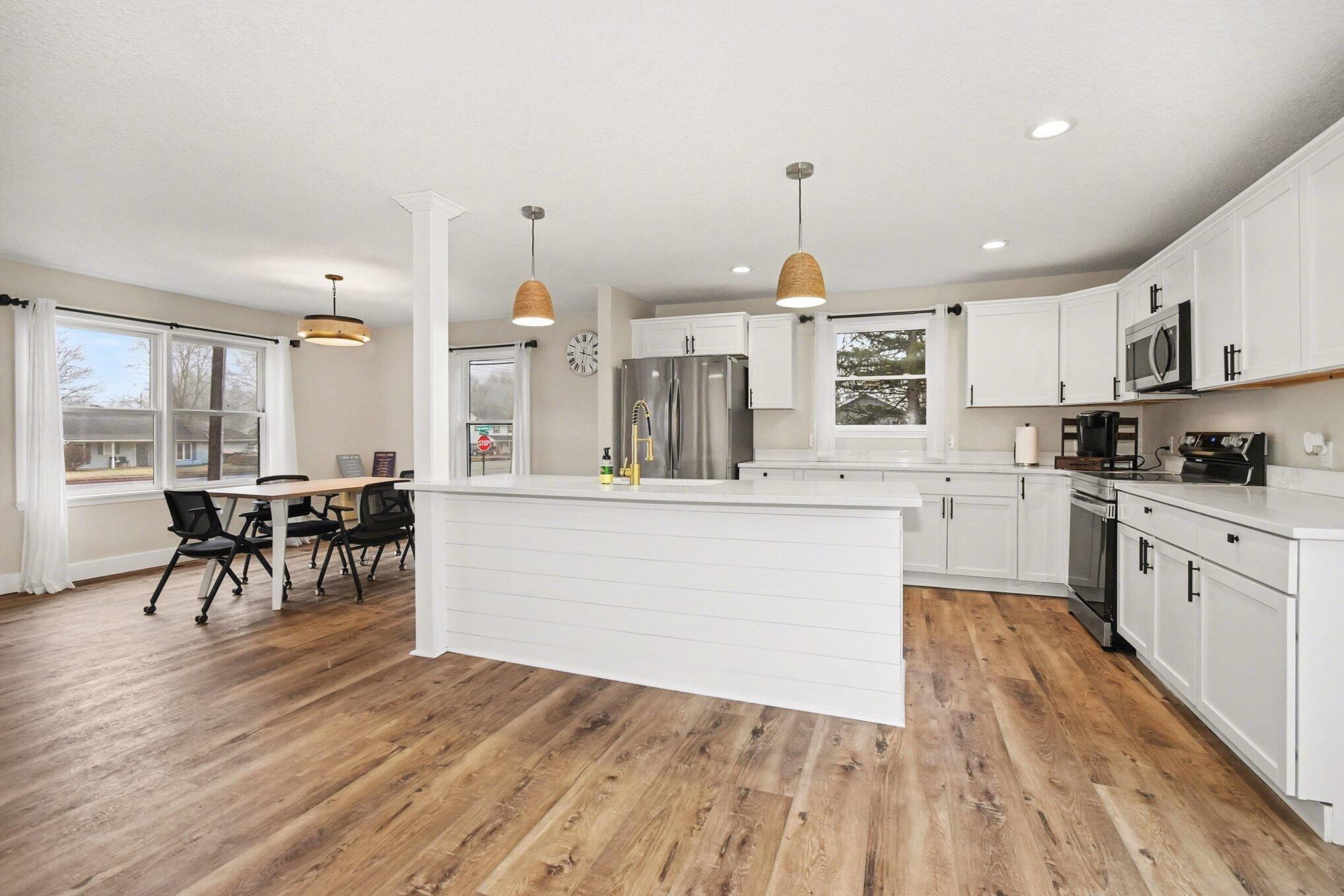 5317 Stellhorn Road Fort Wayne, IN 46815 - Photo 17 of 29 a kitchen with stainless steel appliances granite countertop a stove top oven a sink a dining table and chairs with wooden floor