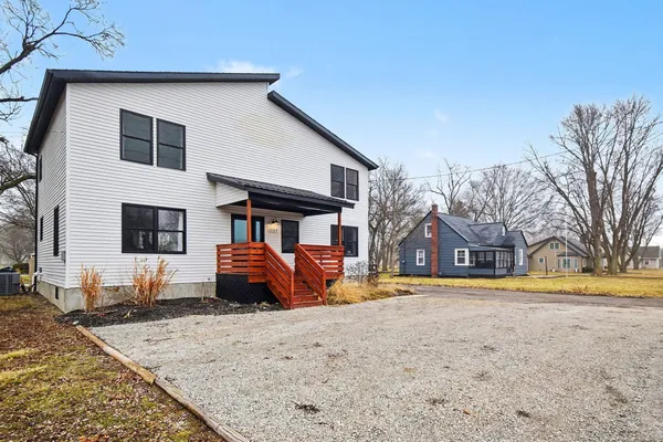 a front view of a house with a yard covered in snow
