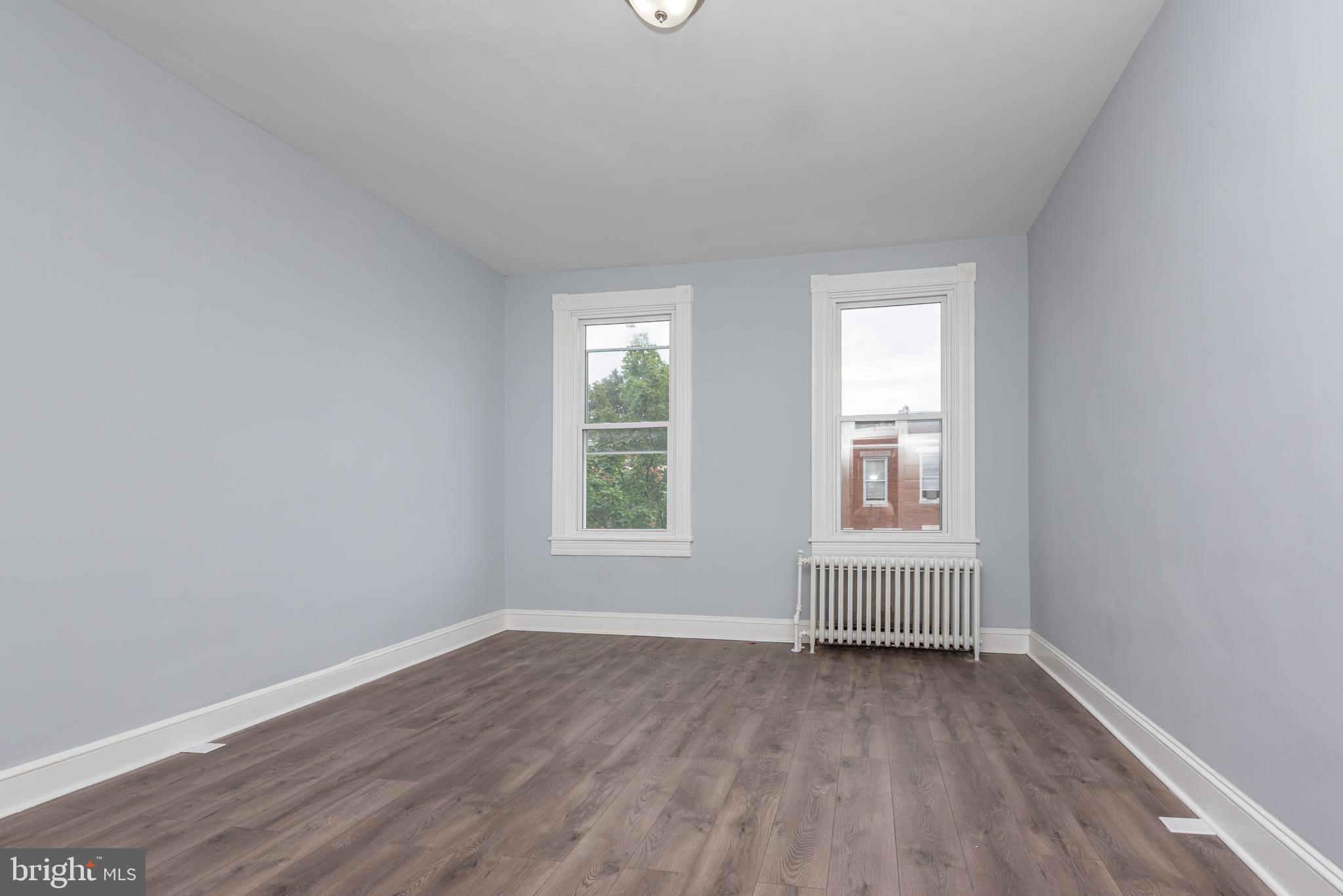 1624 Darley Avenue Baltimore, MD 21213 - Photo 19 of 28 an empty room with wooden floor and windows