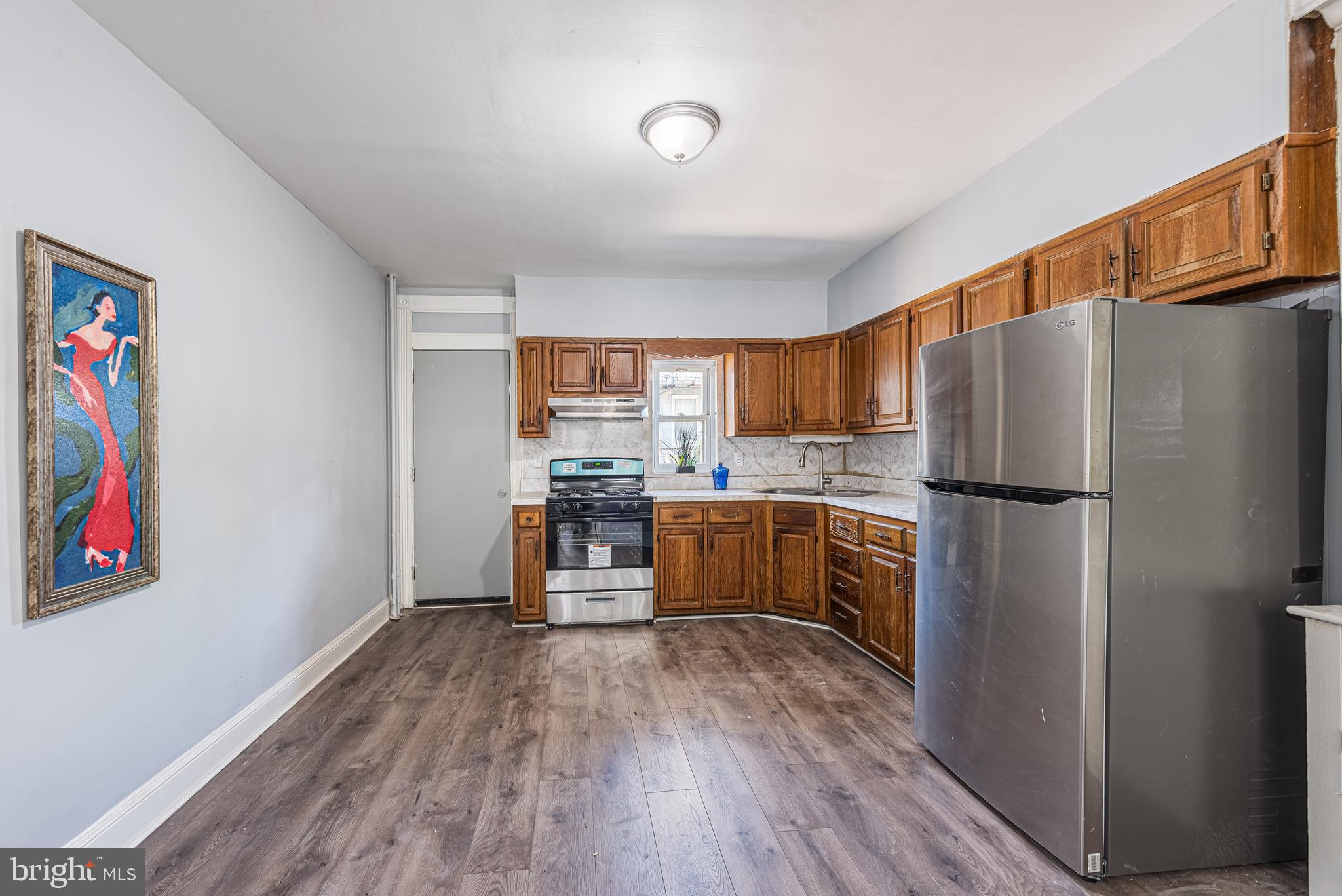1624 Darley Avenue Baltimore, MD 21213 - Photo 8 of 28 a kitchen with granite countertop stainless steel appliances a refrigerator and a stove top oven