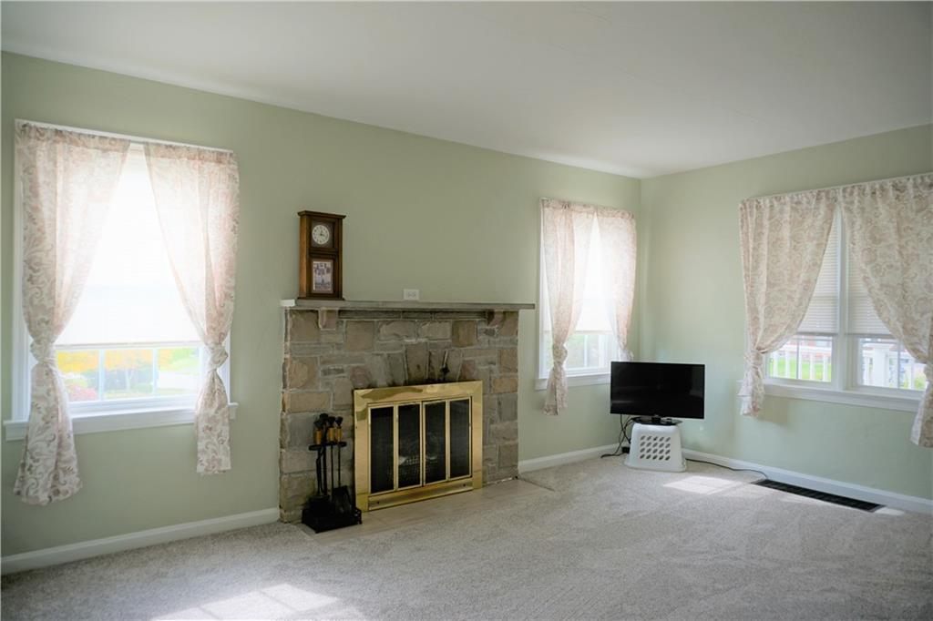 215 Freeport Road Butler, PA 16002 - Photo 11 of 25 a living room with furniture a flat screen tv and a fireplace