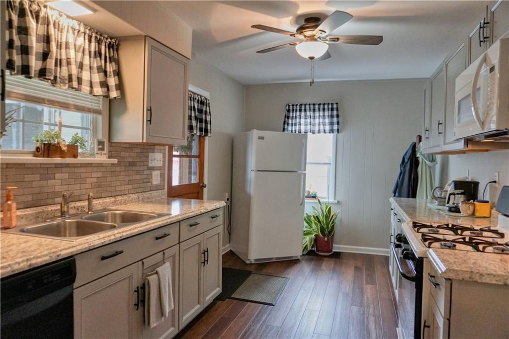215 Freeport Road Butler, PA 16002 - Photo 8 of 25 a kitchen with stainless steel appliances granite countertop a refrigerator a sink dishwasher a stove and a dining table with wooden floor