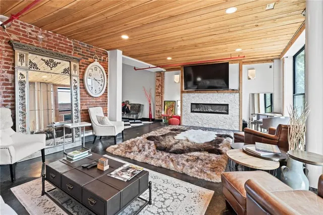 a living room with furniture a flat screen tv and a fireplace