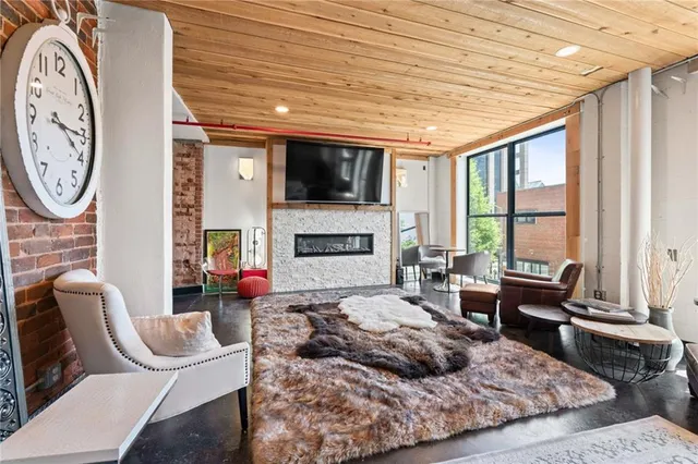 a living room with furniture a flat screen tv and a fireplace